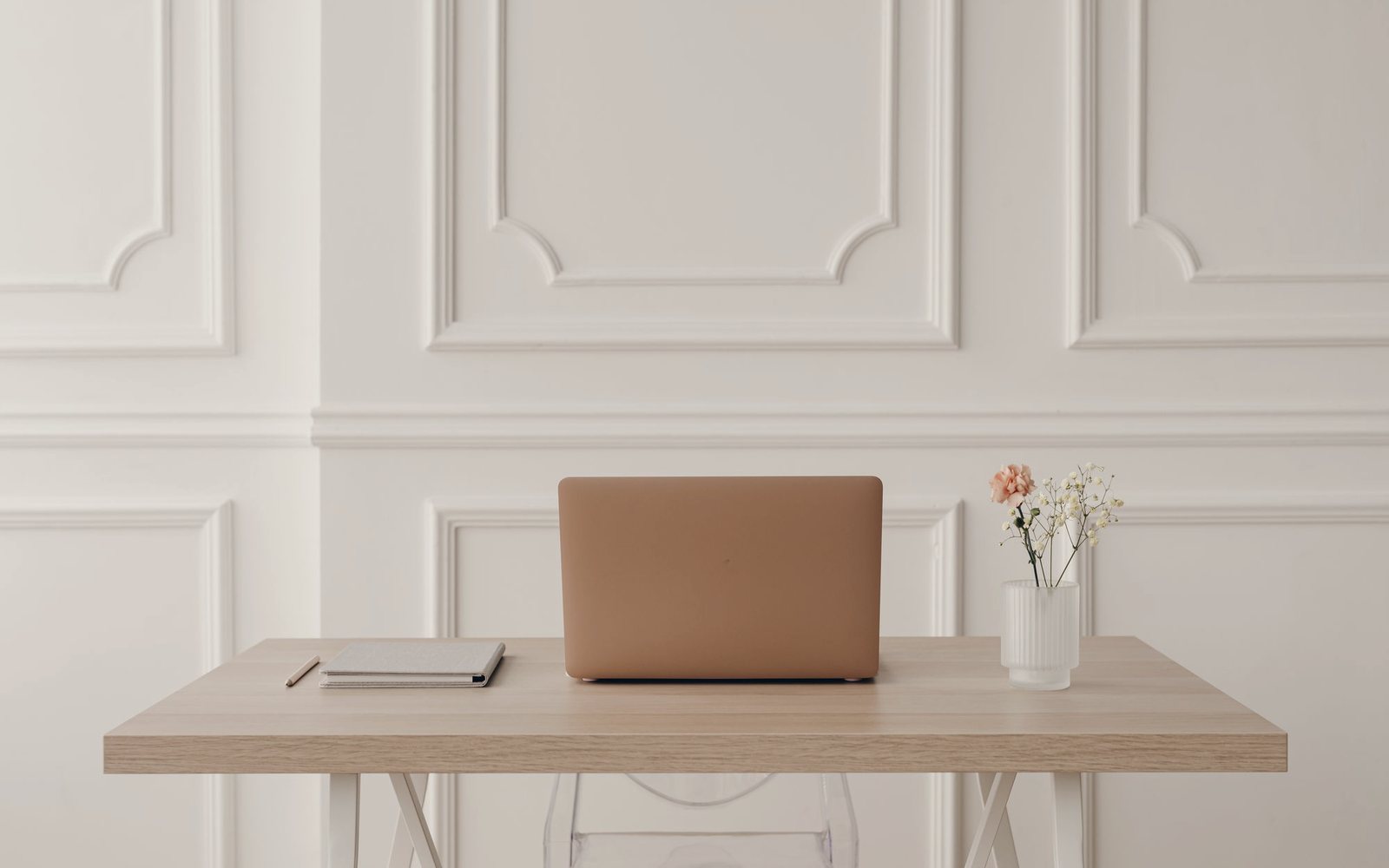 Temporary photograph of a calm workspace with laptop, notebook and flowers